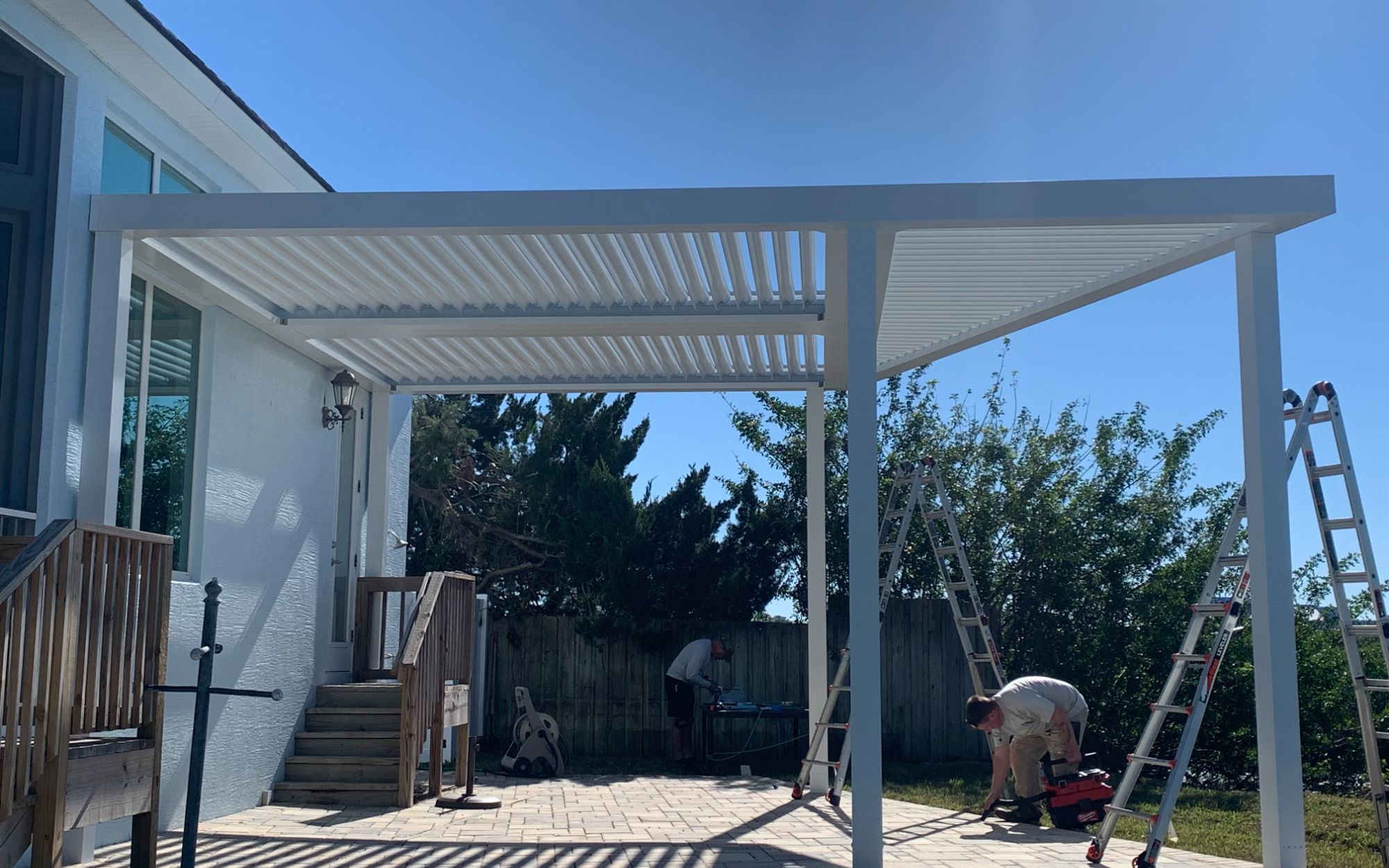 Titan Outdoor Solutions technician installing StruXure pergola Northeast Florida professional installation