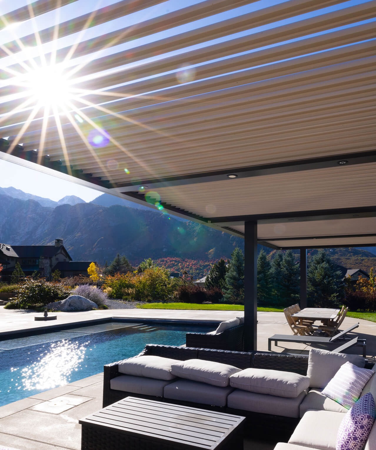 Modern patio with adjustable motorized pergola roof overlooking scenic mountain and pool view