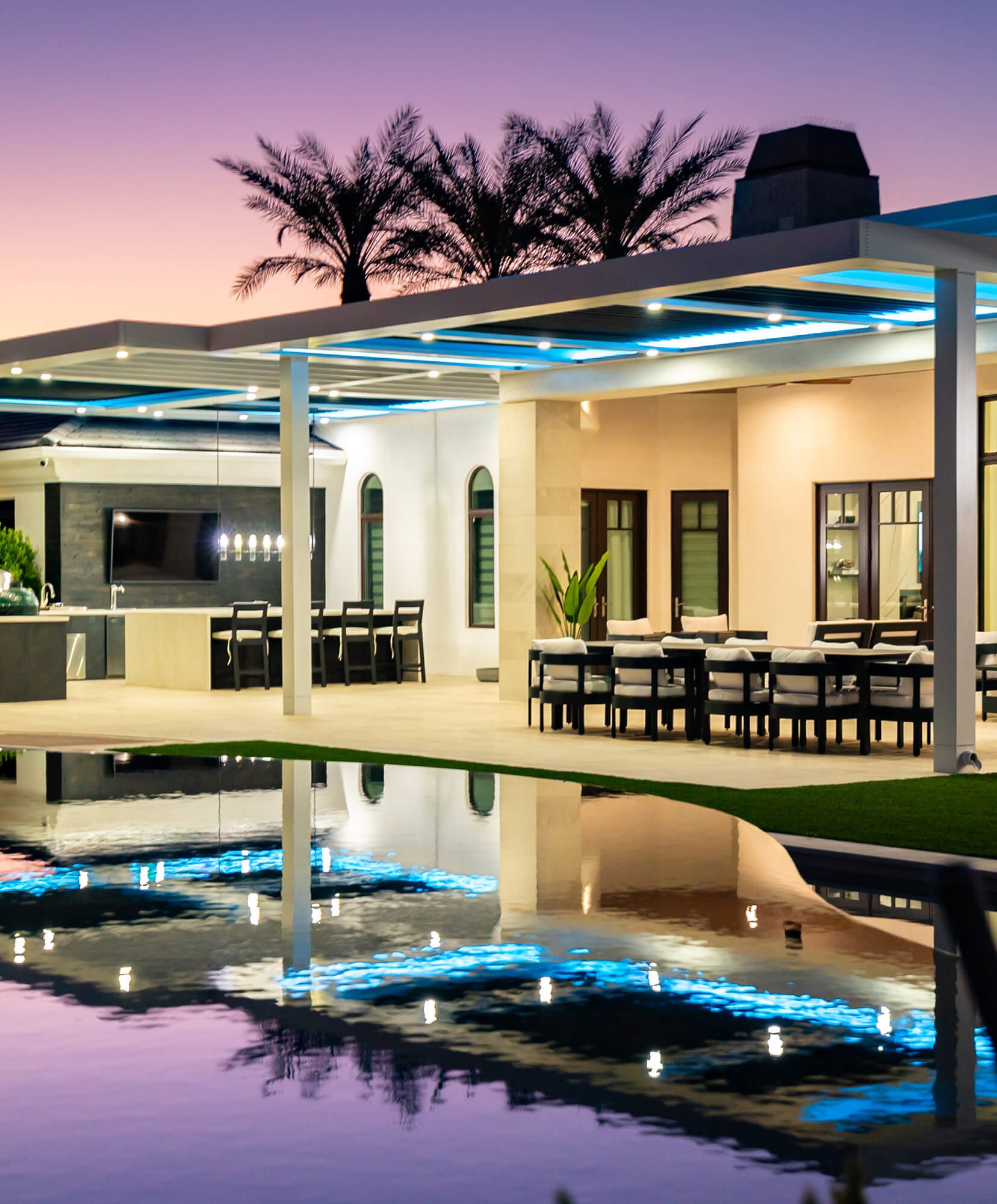 Luxury backyard pool area with motorized pergola and integrated lighting for stylish outdoor living and entertaining
