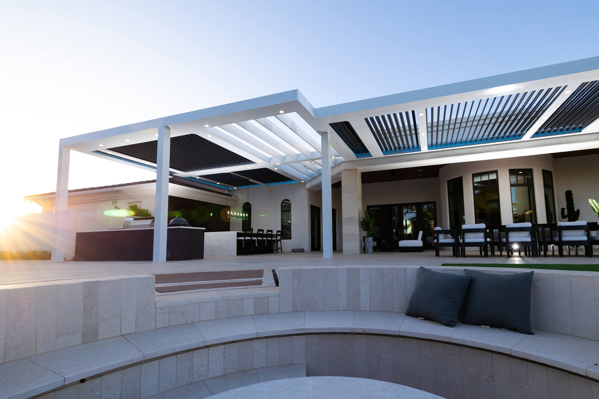 Contemporary outdoor lounge seating under a sleek motorized pergola for sun and rain protection