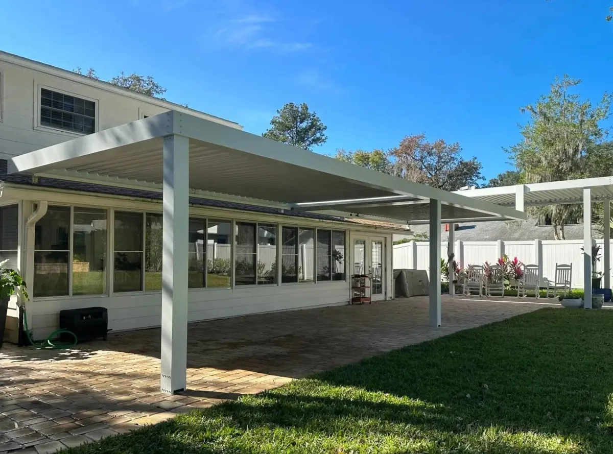 Large freestanding white StruXure pergola over open lawn area St. Augustine Florida