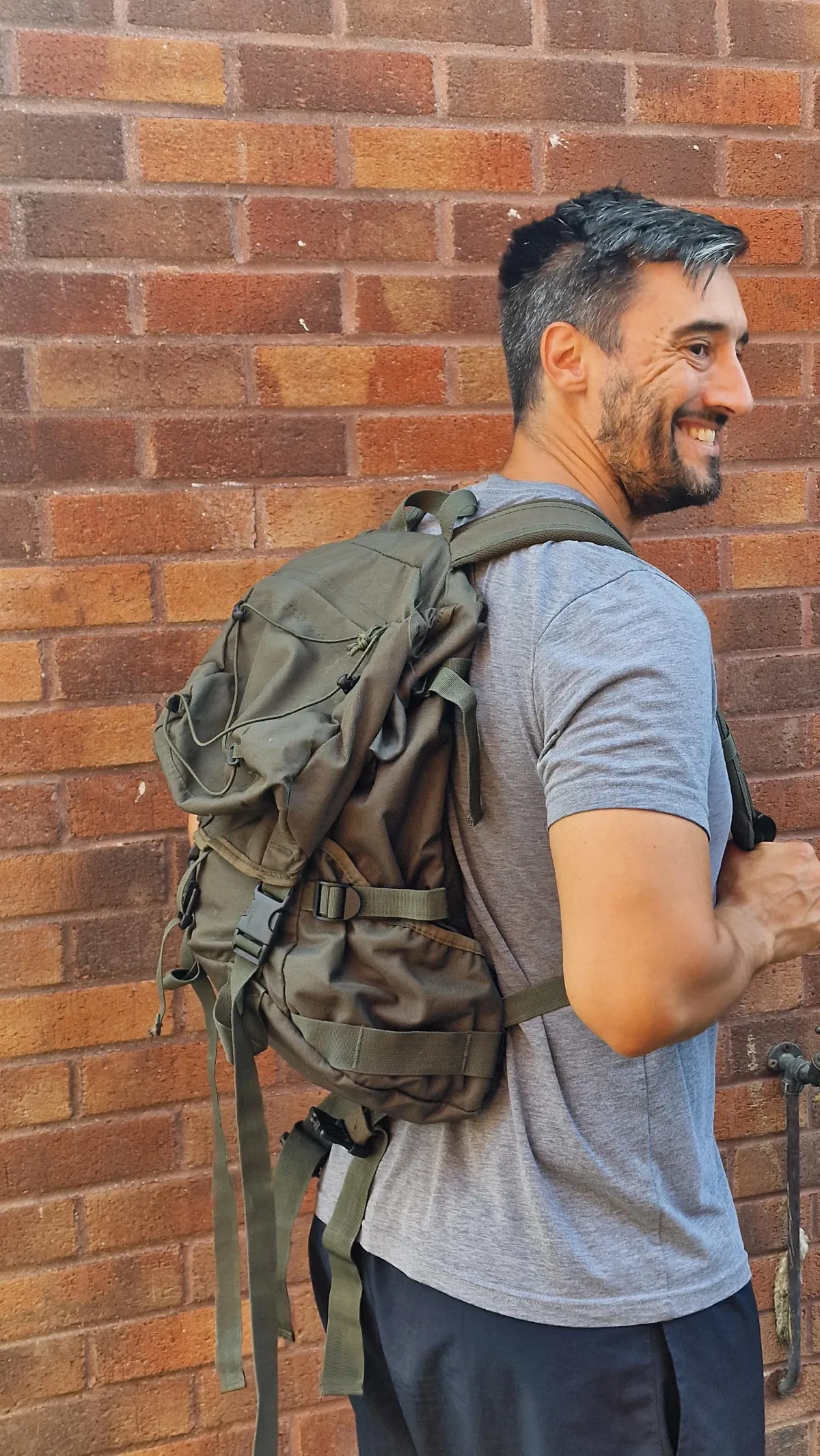 A high-level athlete carrying a heavy 20kg ruck outdoors