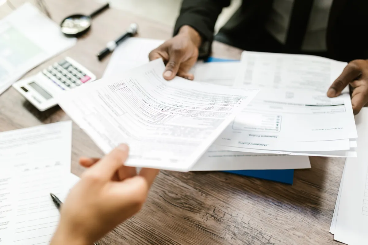 Person handing a document to another person