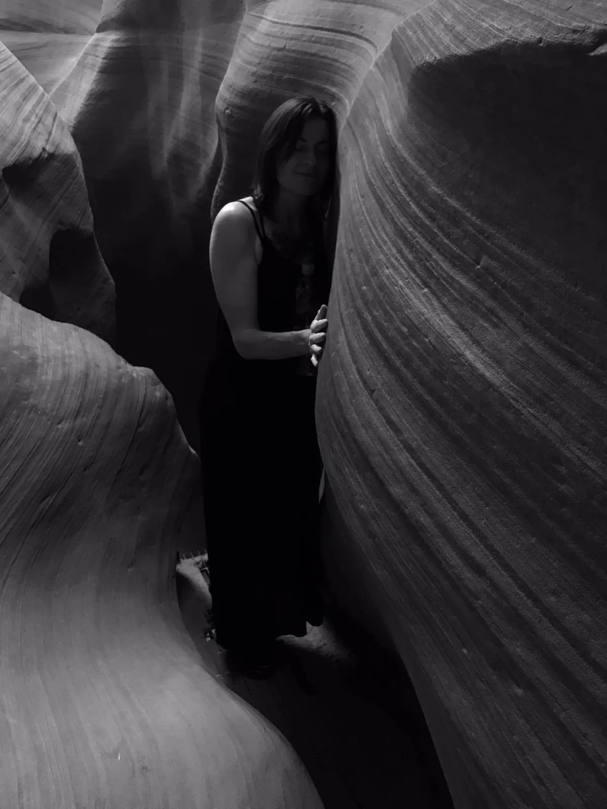 Woman standing in narrow canyon, symbolizing deep self-exploration, sacred feminine journey, and connection to nature’s transformative power.