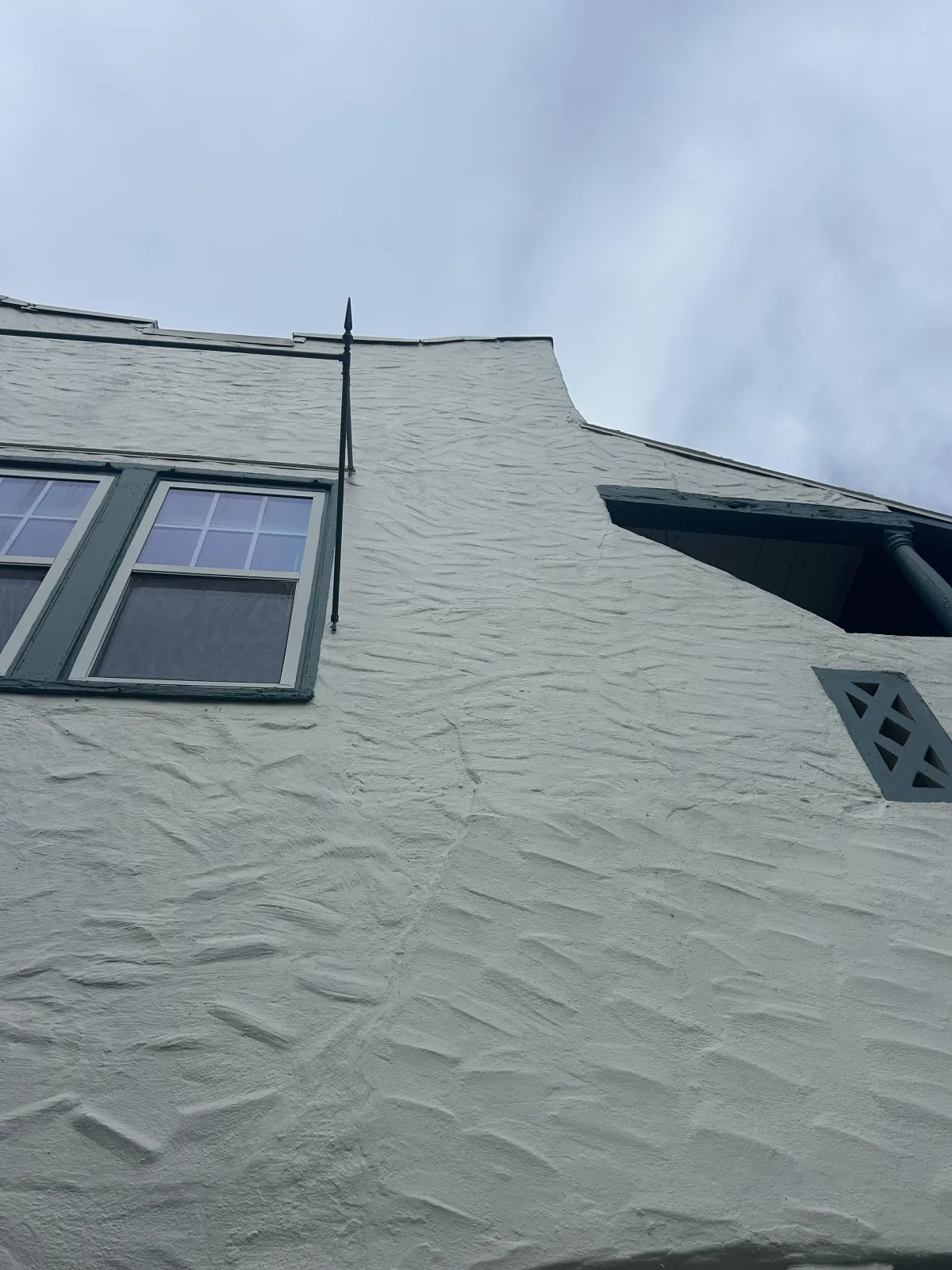 texturesd grey stucco on a house with two windows