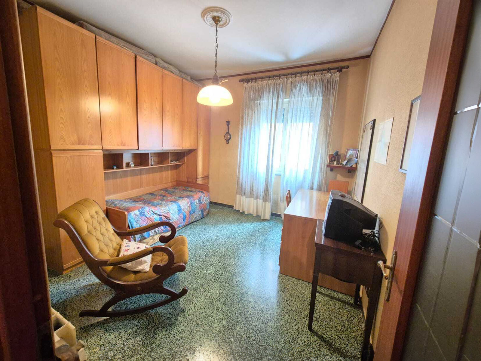 Formal dining area with a sculpted glass table, designer chairs, and a statement chandelier, set against a backdrop of city lights. 3:2 aspect ratio.