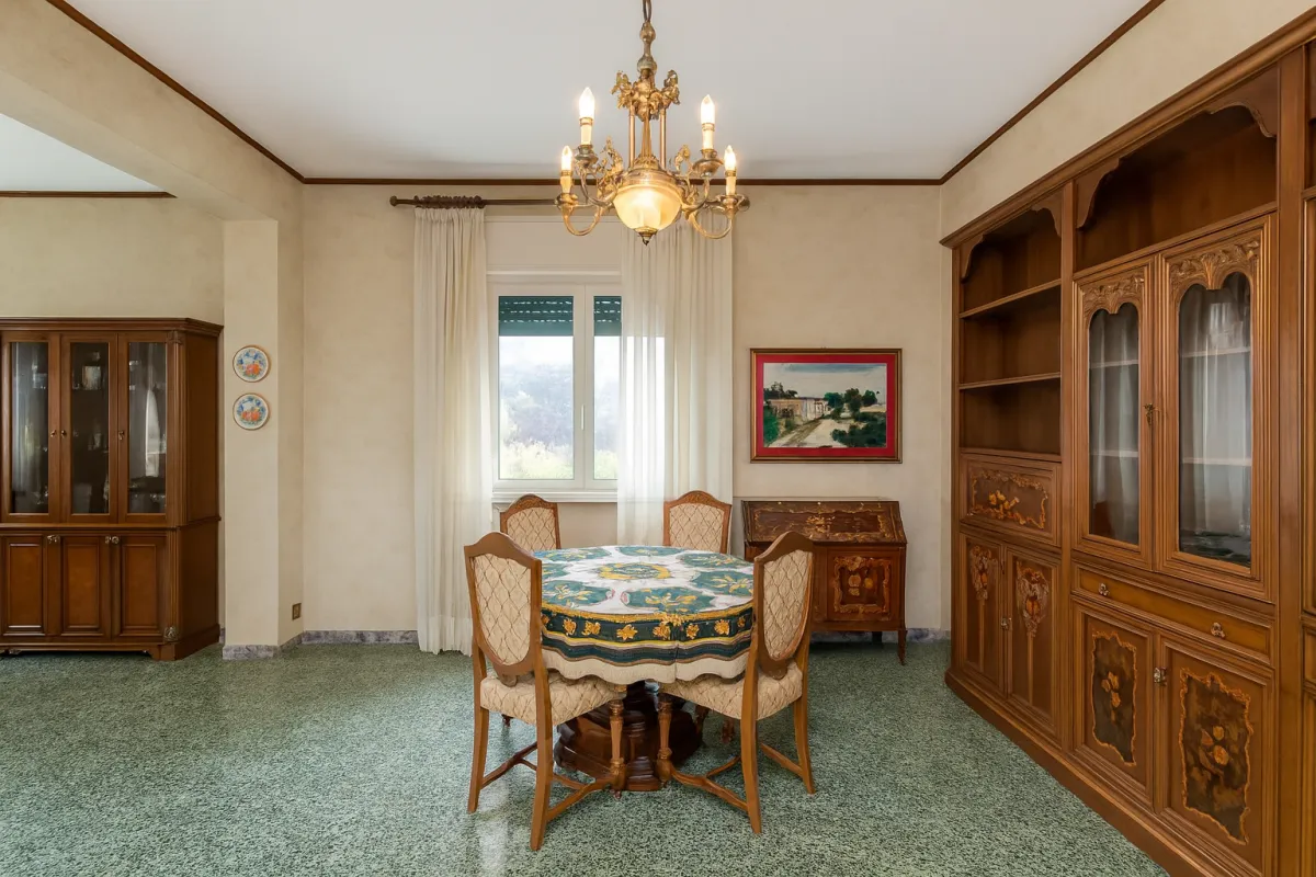 Spacious open-plan kitchen with marble island, high-end appliances, and sculptural pendant lighting, reflecting a minimalist yet warm design. 3:2 aspect ratio.