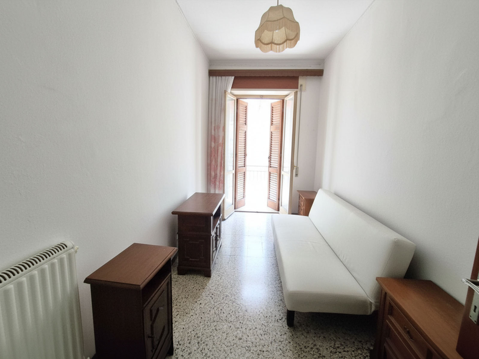 Expansive balcony lounge with plush seating, glass railing, and lush potted plants, overlooking the city at sunset. 3:2 aspect ratio.