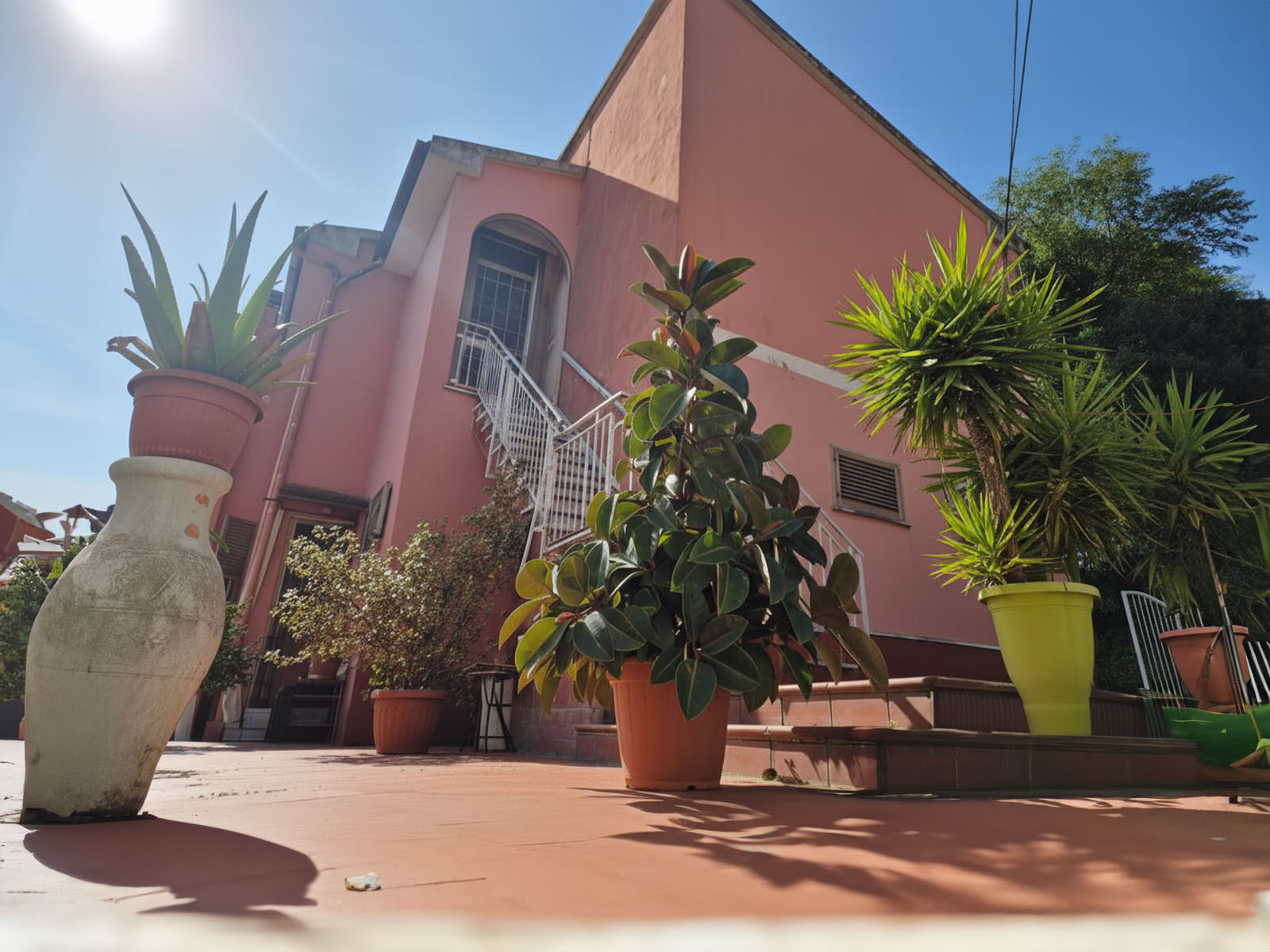 Aerial twilight shot of the building’s rooftop terrace with infinity pool, glass balustrades, and ambient lighting, overlooking the illuminated cityscape. 3:2 aspect ratio.