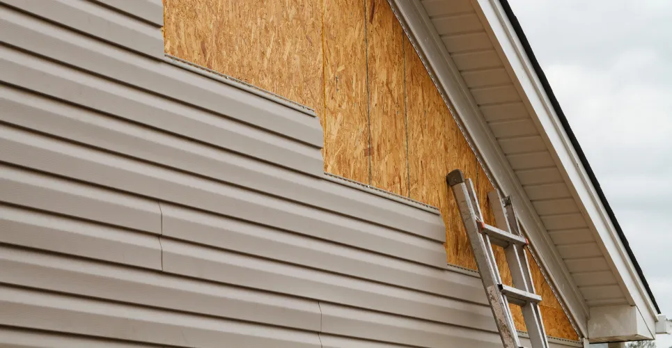 Exterior home renovation showing new siding, garage door, and updated trim work