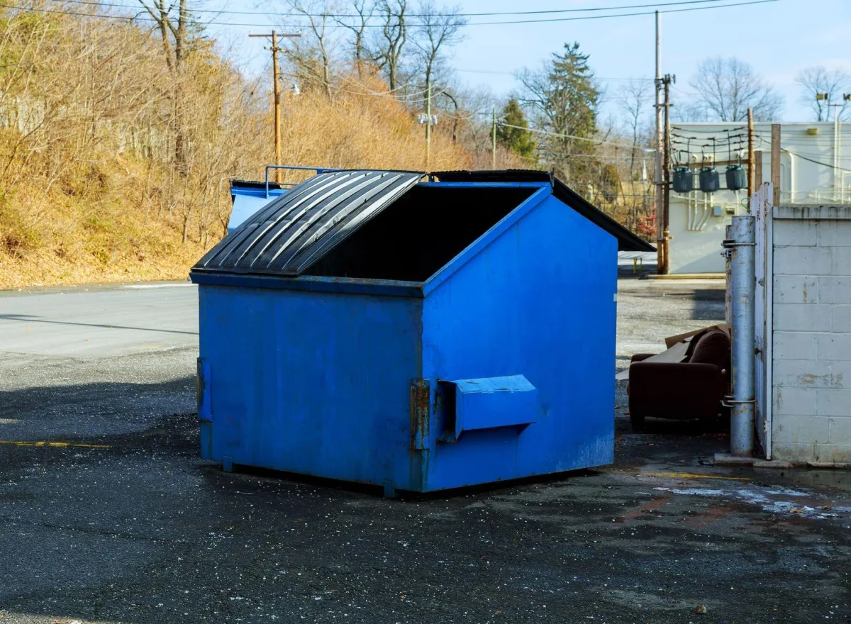 Blue commercial dumpster during pre-cleaning assessment