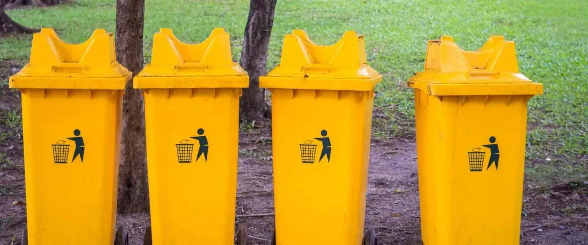 Yellow trash bins in a park for waste disposal
