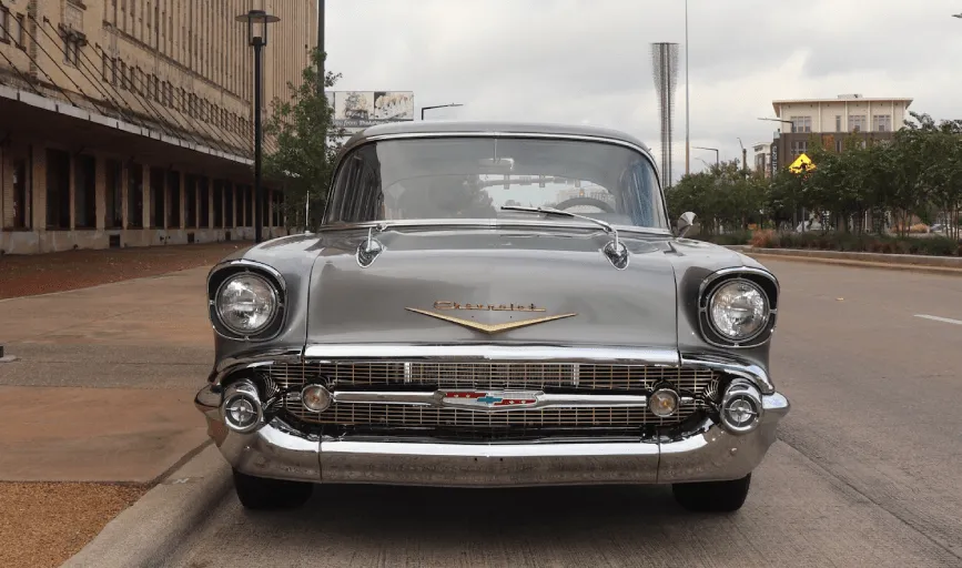 A vintage green convertible car parked at night.