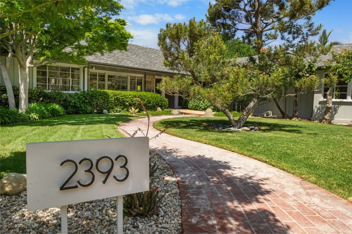 Front exterior of a Somas home with landscaped yard and stone entryway