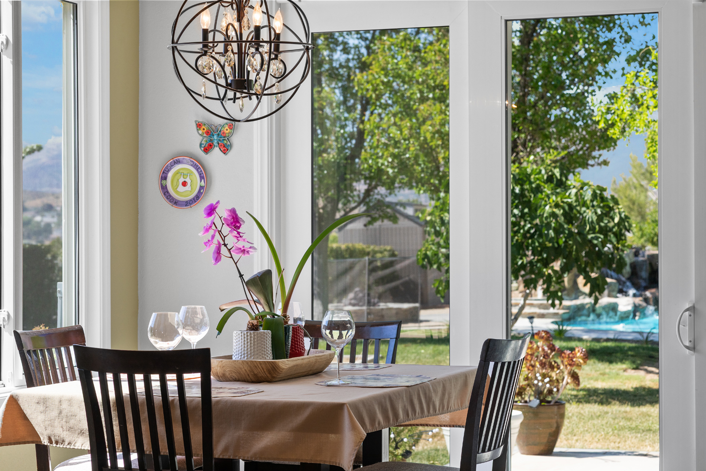 Sunlit breakfast nook with large windows and garden views