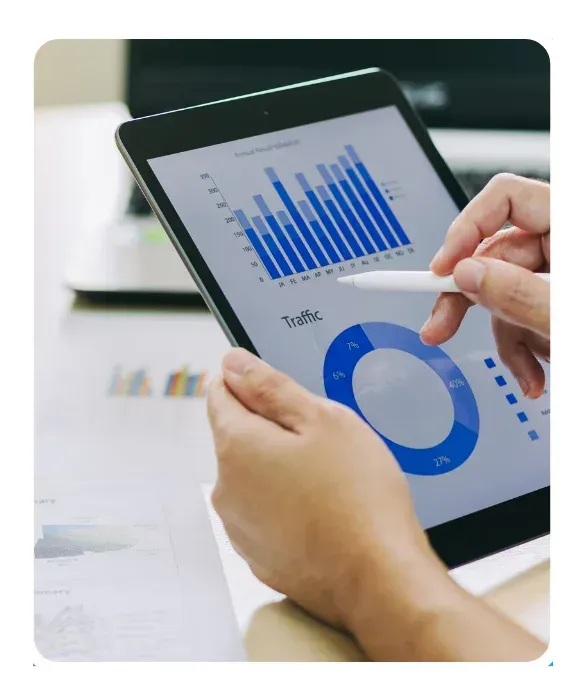 Digital marketing strategy meeting in progress with analytics and website performance graphs displayed on a tablet.
