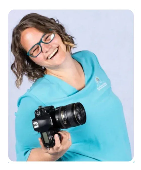 Ellie Clare from CLP Advertising smiling and holding a professional camera, representing the supportive and creative approach behind CLP’s DIY Marketing Pathways.