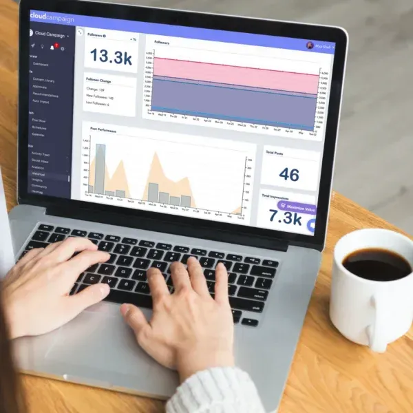 Person working on a laptop displaying Cloud Campaign analytics dashboard used for social media scheduling and reporting.