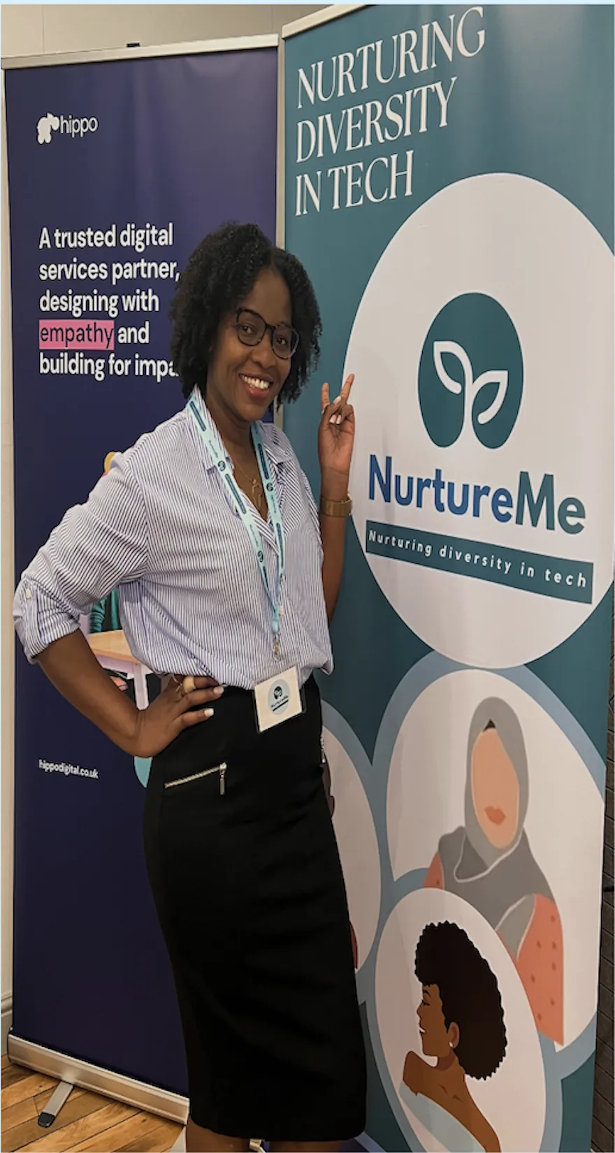 Photo of a women with curly afro hair, wearing a black skirt and stripped shirt
