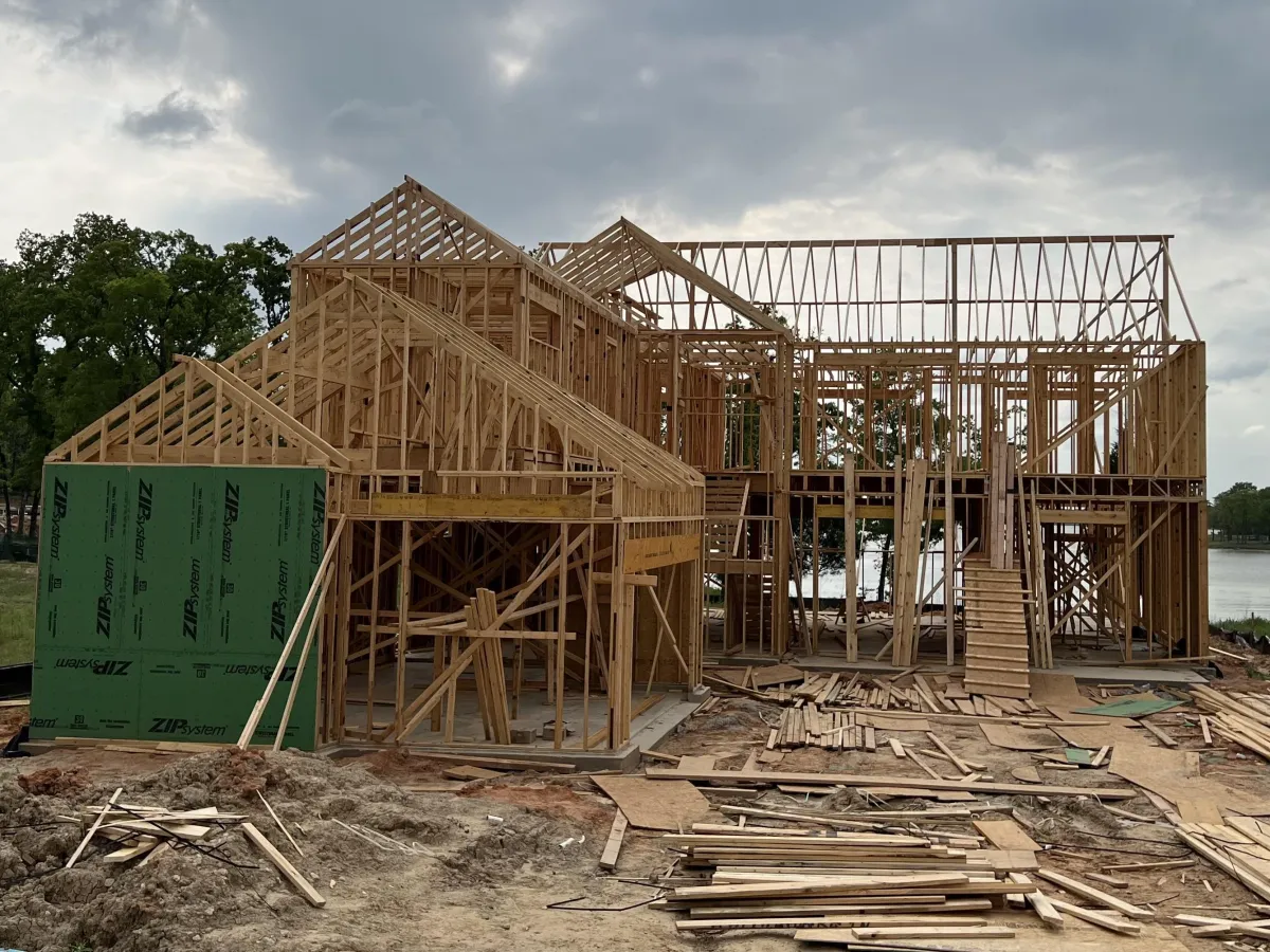 Residential house framing in progress showing exterior wall framing and structural layout