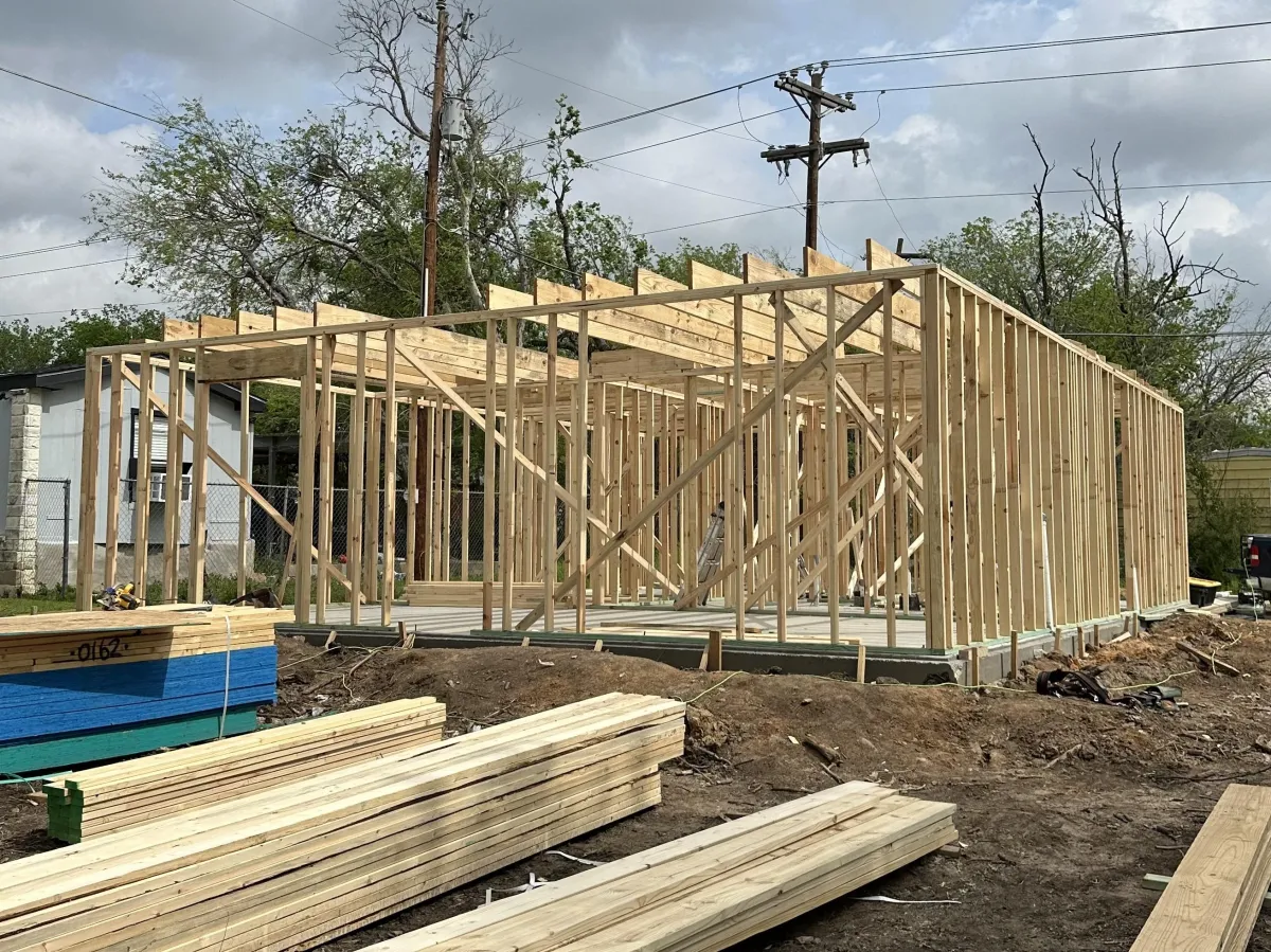 New home framing with exposed wood framing, roof structure, and load-bearing walls