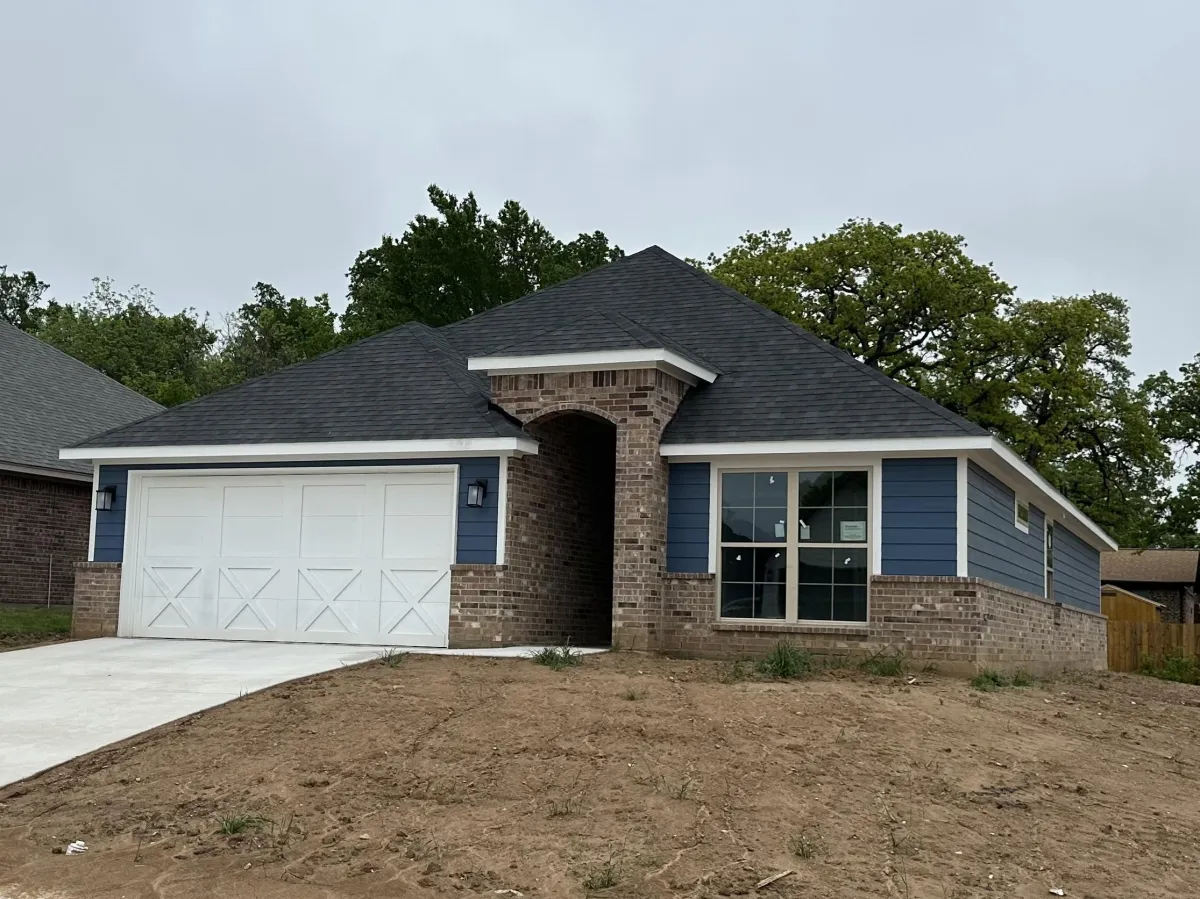 Residential house framing in progress showing exterior wall framing and structural layout