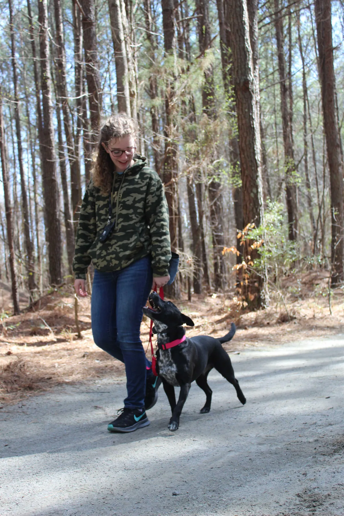 woman carrying and kissing dog