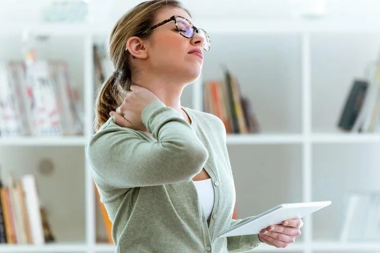 mujeres sosteniendo su cuello con dolor