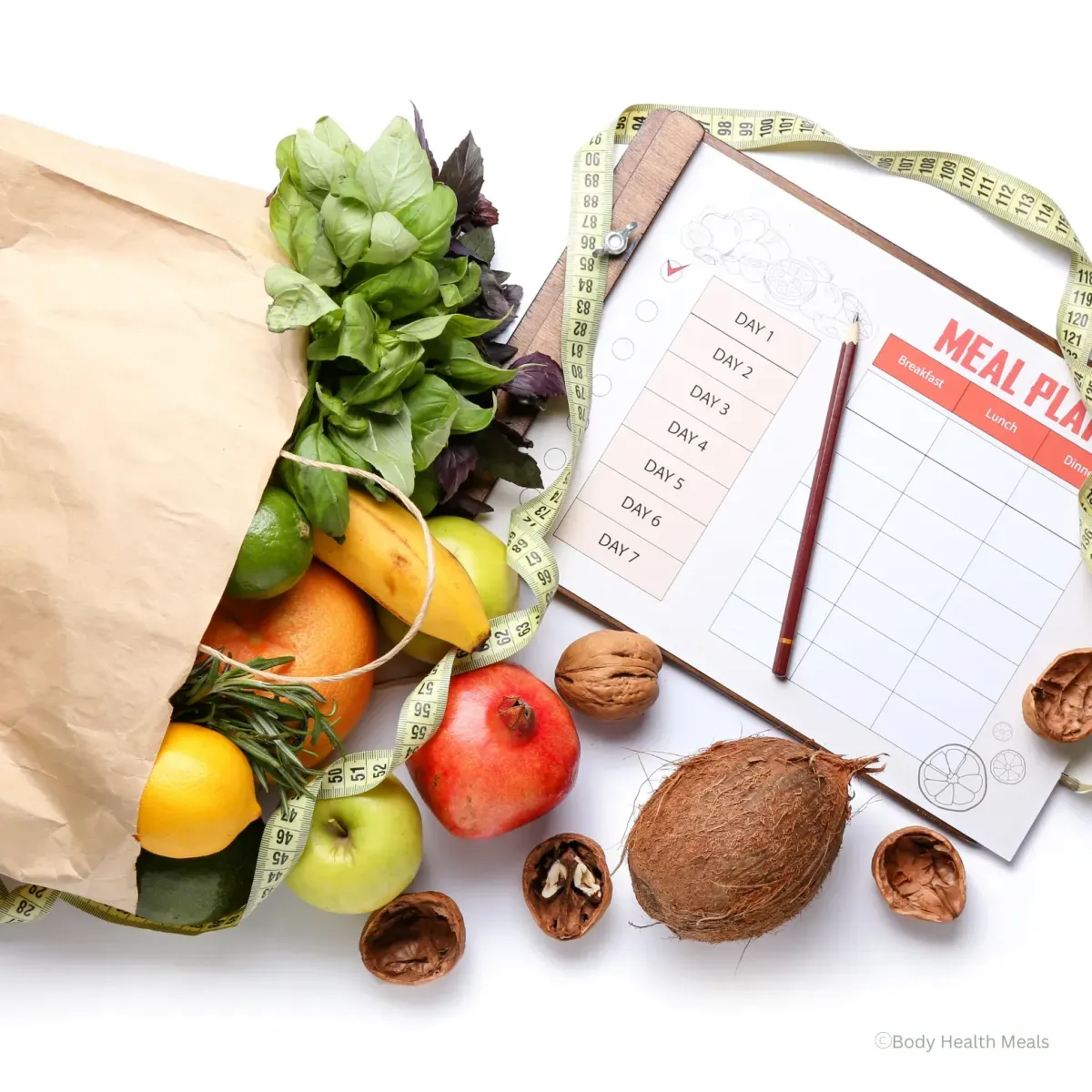 Paper grocery bag filled with fresh produce next to a meal planning sheet and measuring tape, representing healthy meal planning for busy moms.