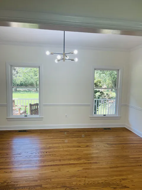 Painter rolling white paint on an interior wall in Easton.