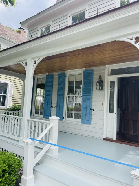 Professional painter from Victory Painting, LLC applying white paint to a wall using a roller