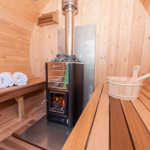 A wood burning stove inside of a wooden cabin