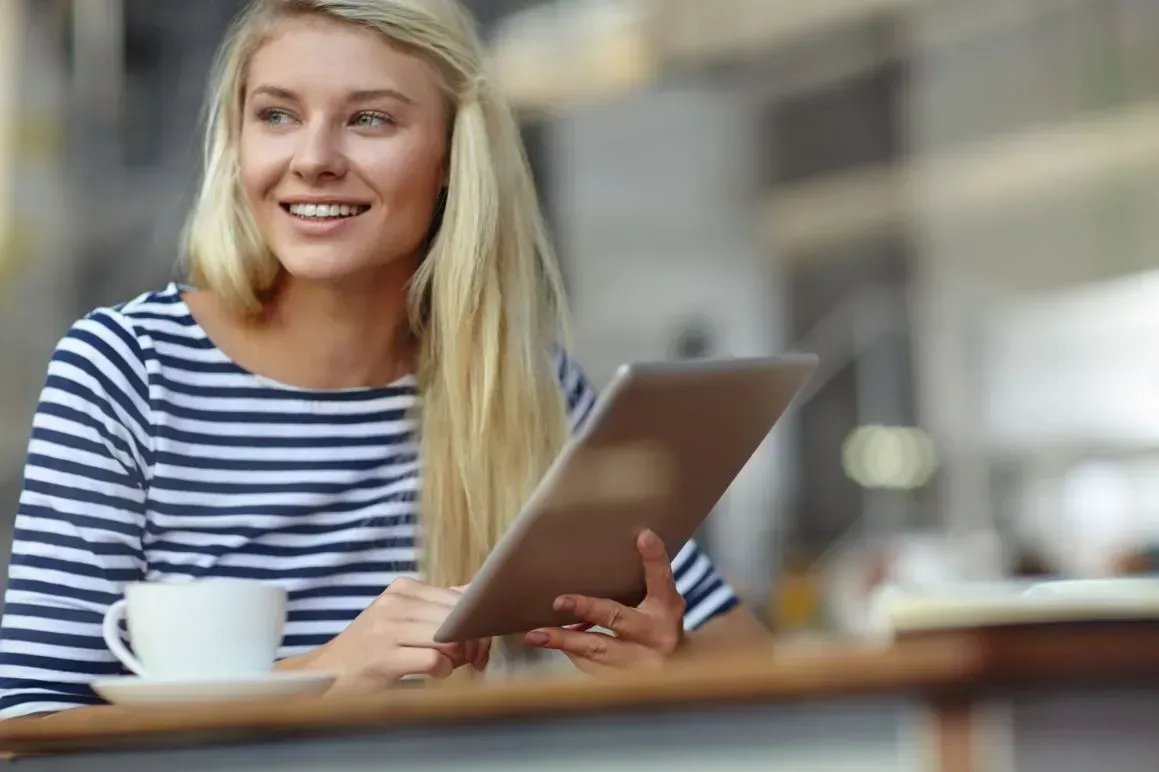 Woman holding a table over a cup of coffee on a table
