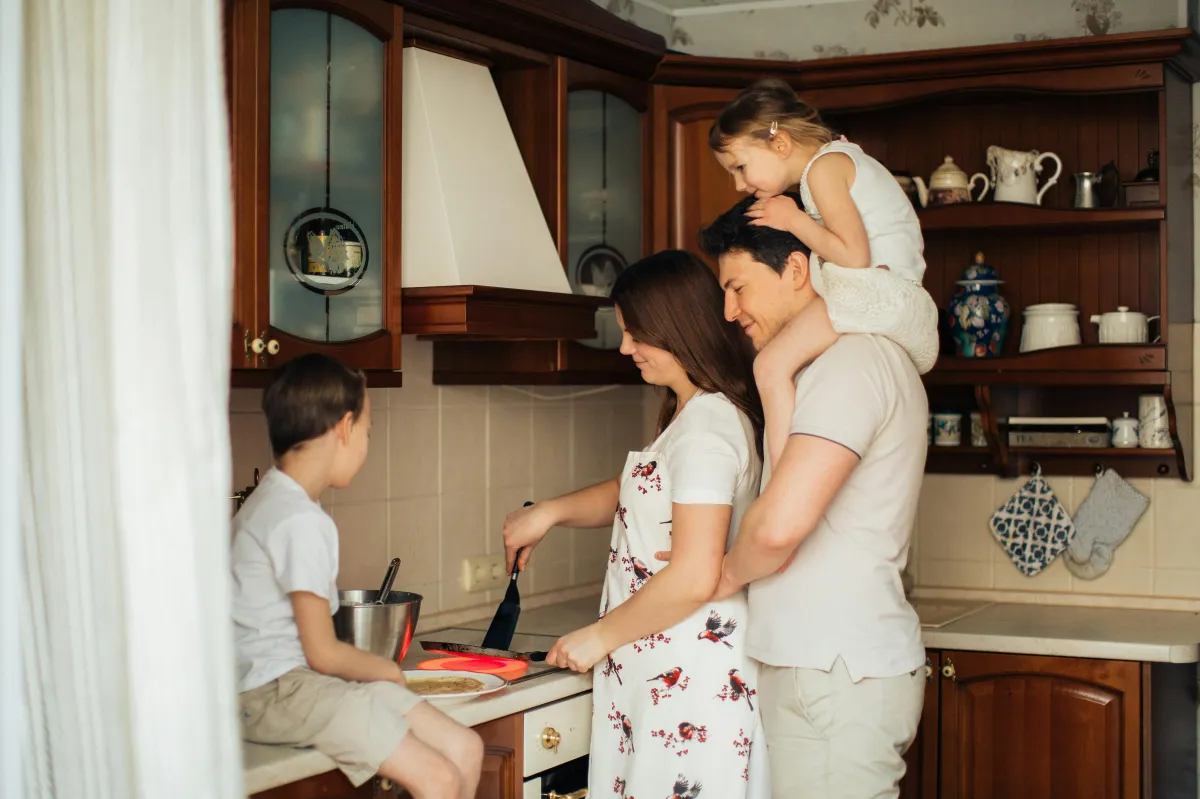 Happy family standing in kitchen of new home protected by mortgage protection insurance