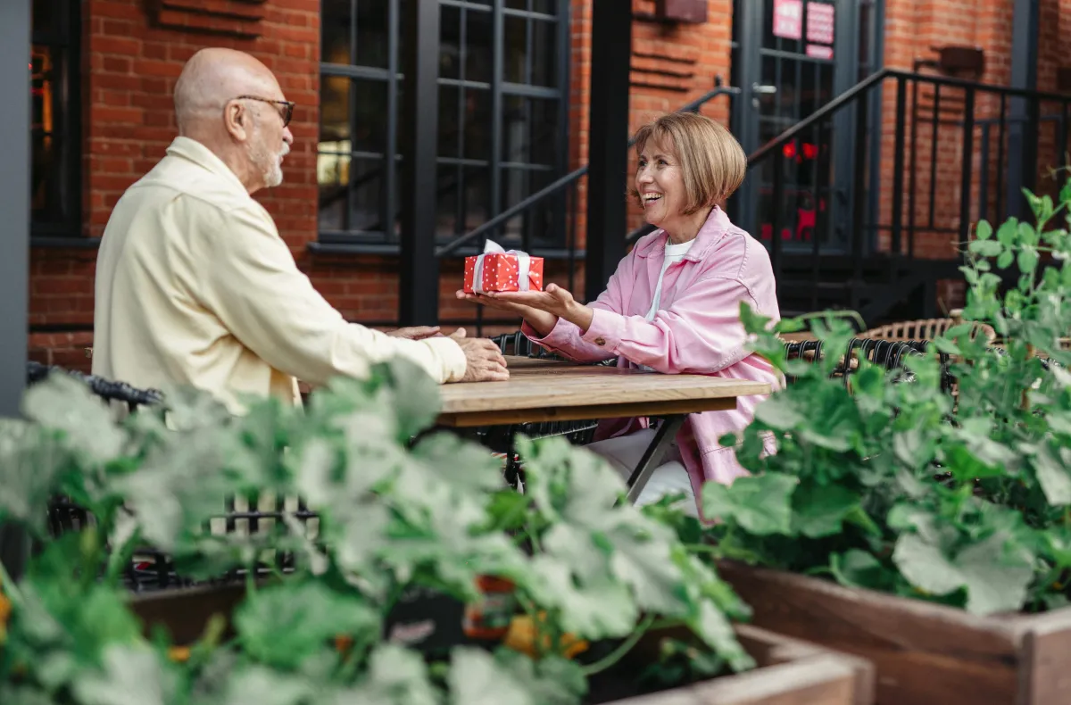 Mature couple smiling outdoors while discussing whole life insurance benefits