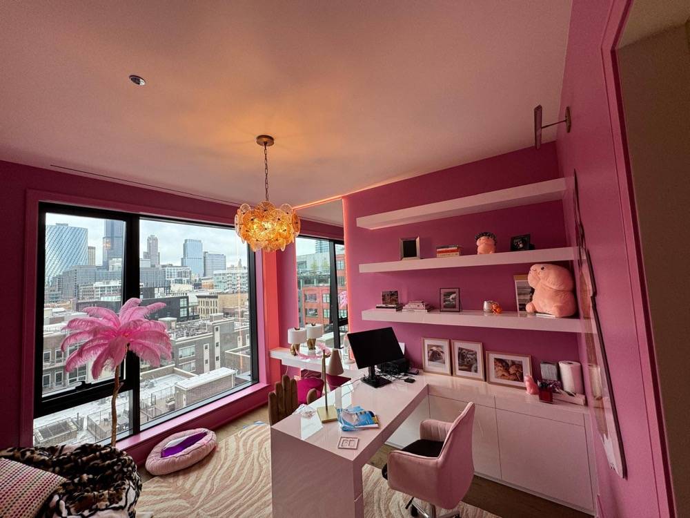 Pink home office with city skyline views, floating shelves and modern decor