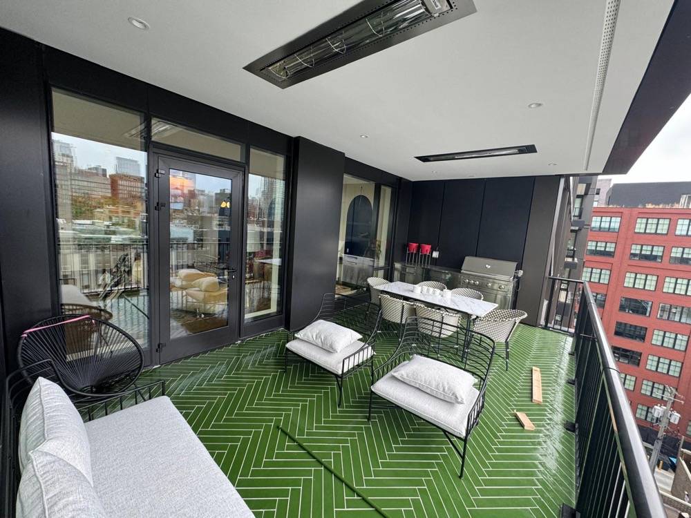 Rooftop terrace with green geometric turf, modern outdoor seating and city views