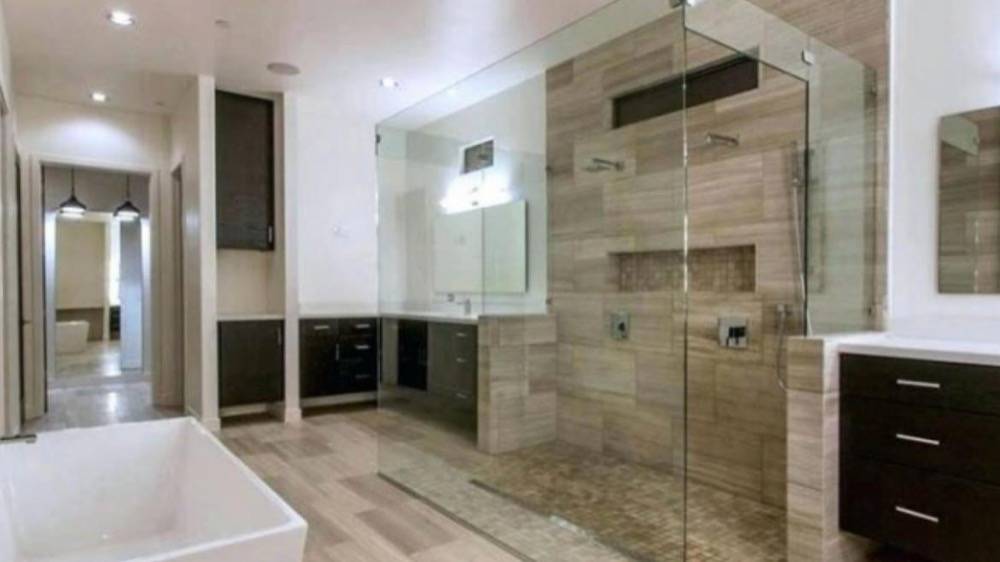 Spacious bathroom remodel with frameless glass shower enclosure and freestanding soaking tub
