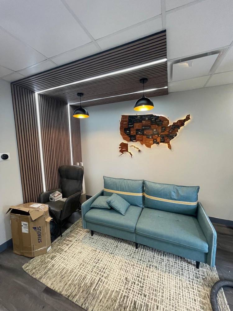 Commercial office lounge with slatted wood accent wall and decorative US map artwork