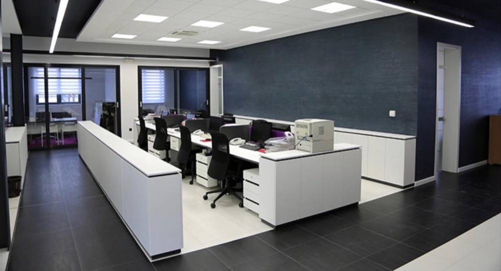 Modern commercial office buildout with open workstation layout and dark accent wall