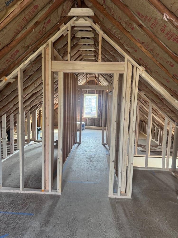 Attic renovation framing with exposed roof rafters and new stud walls