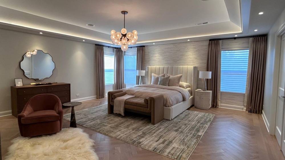 Luxury master bedroom with tray ceiling, chandelier and hardwood flooring