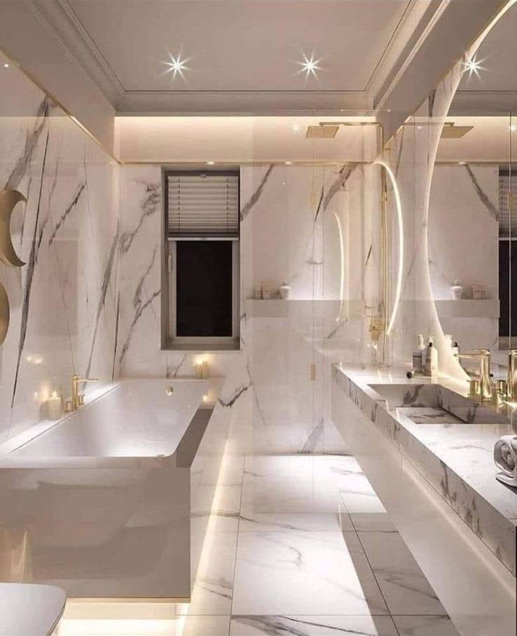 Luxury white marble bathroom with freestanding tub, curved mirror and gold accents