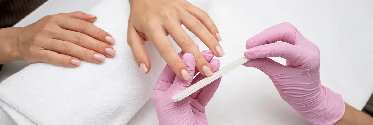 Student practicing manicures during nail school in Apopka at Hyphen Beauty School