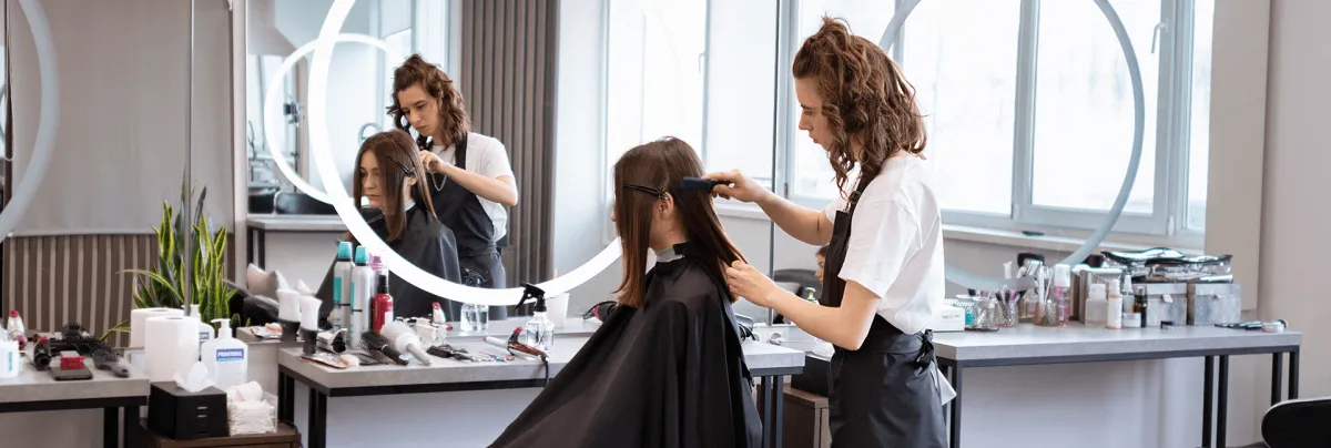 Student performing hair styling during hair school  in Orlando at Hyphen Beauty School