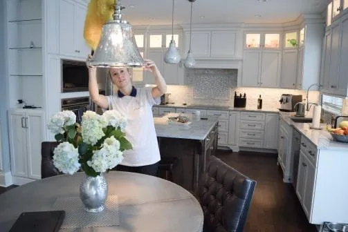 a cleaning expert from arrow cleaning solution cleaning the light fixtures