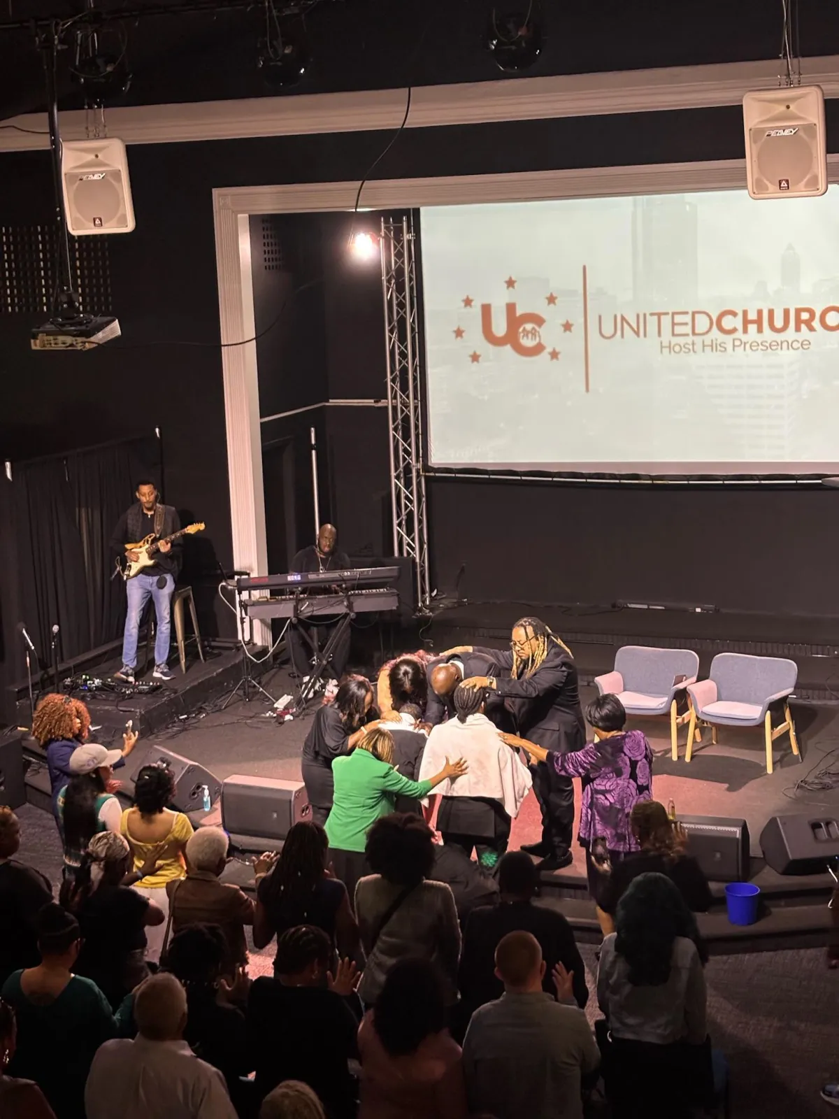 people sitting on chair in front of table while holding pens during daytime