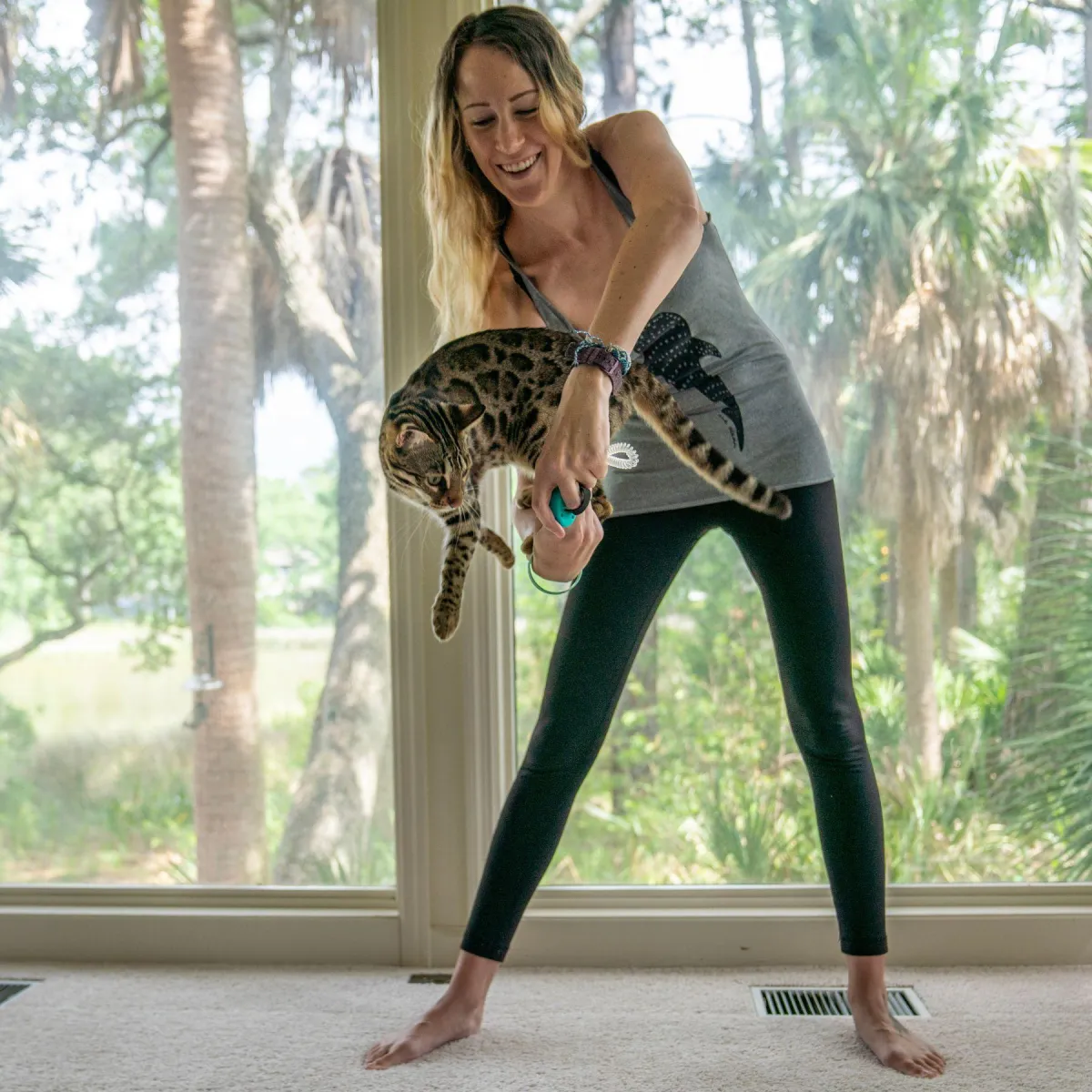 bengal cat jumping through girl's arm