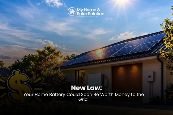 A modern home battery mounted on a garage wall, glowing as power flows from the home to the grid during a summer evening.