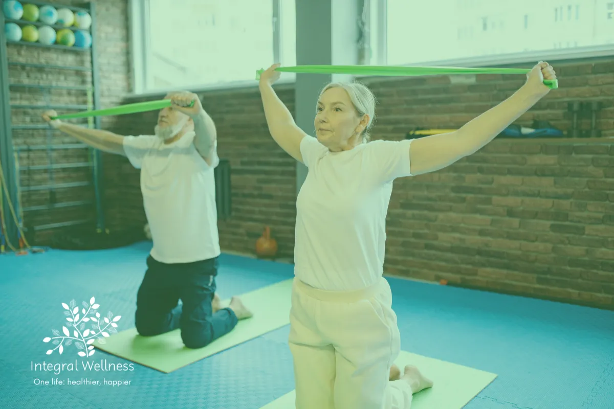 Older adults exercising with resistance bands in a bright fitness studio at Integral Wellness, demonstrating strength, mobility, and active aging.